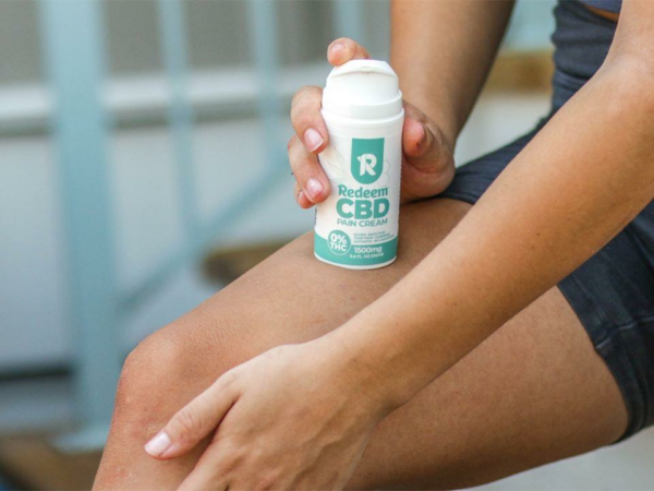 Woman applying CBD Pain Cream to her leg