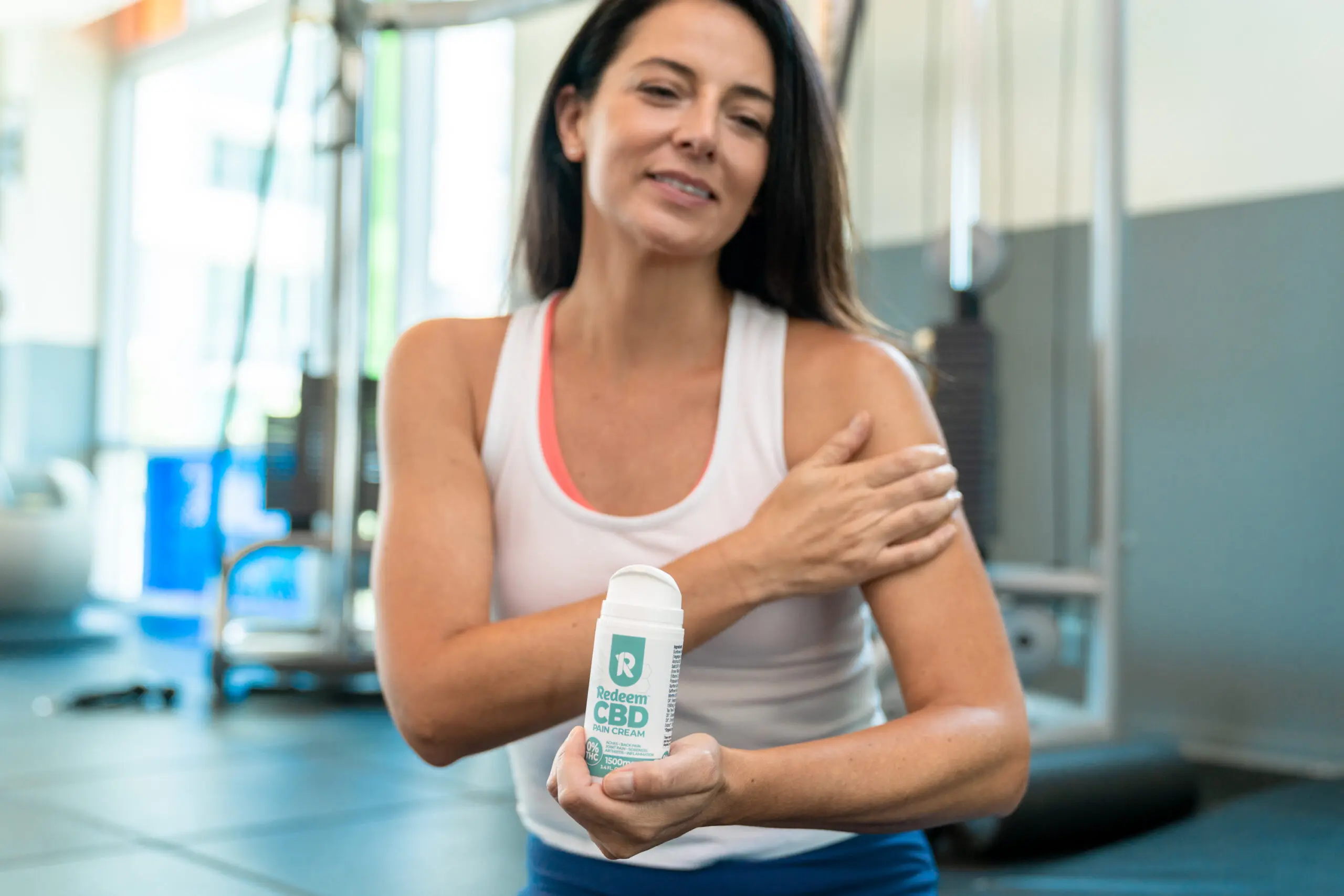 Woman applying CBD Pain Cream to her arm