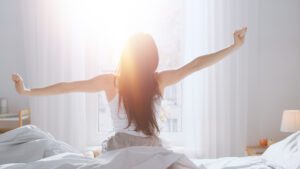 woman stretching after a good nights sleep after using cbd for pain relief and sleep